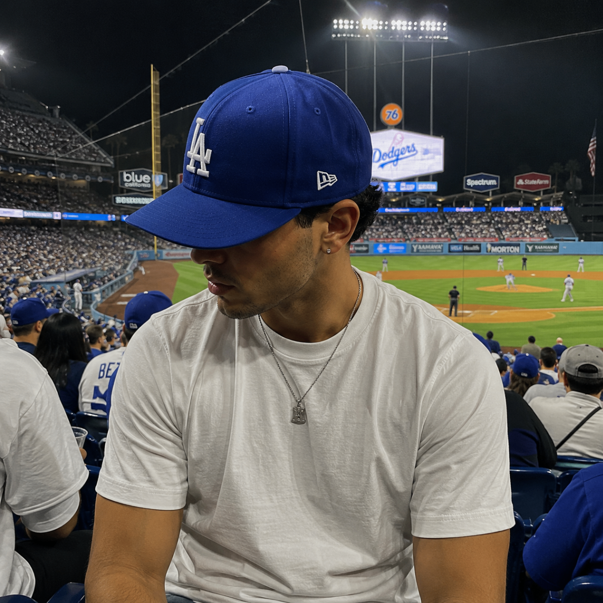 Model wearing a blue cap at a baseball stadium at night